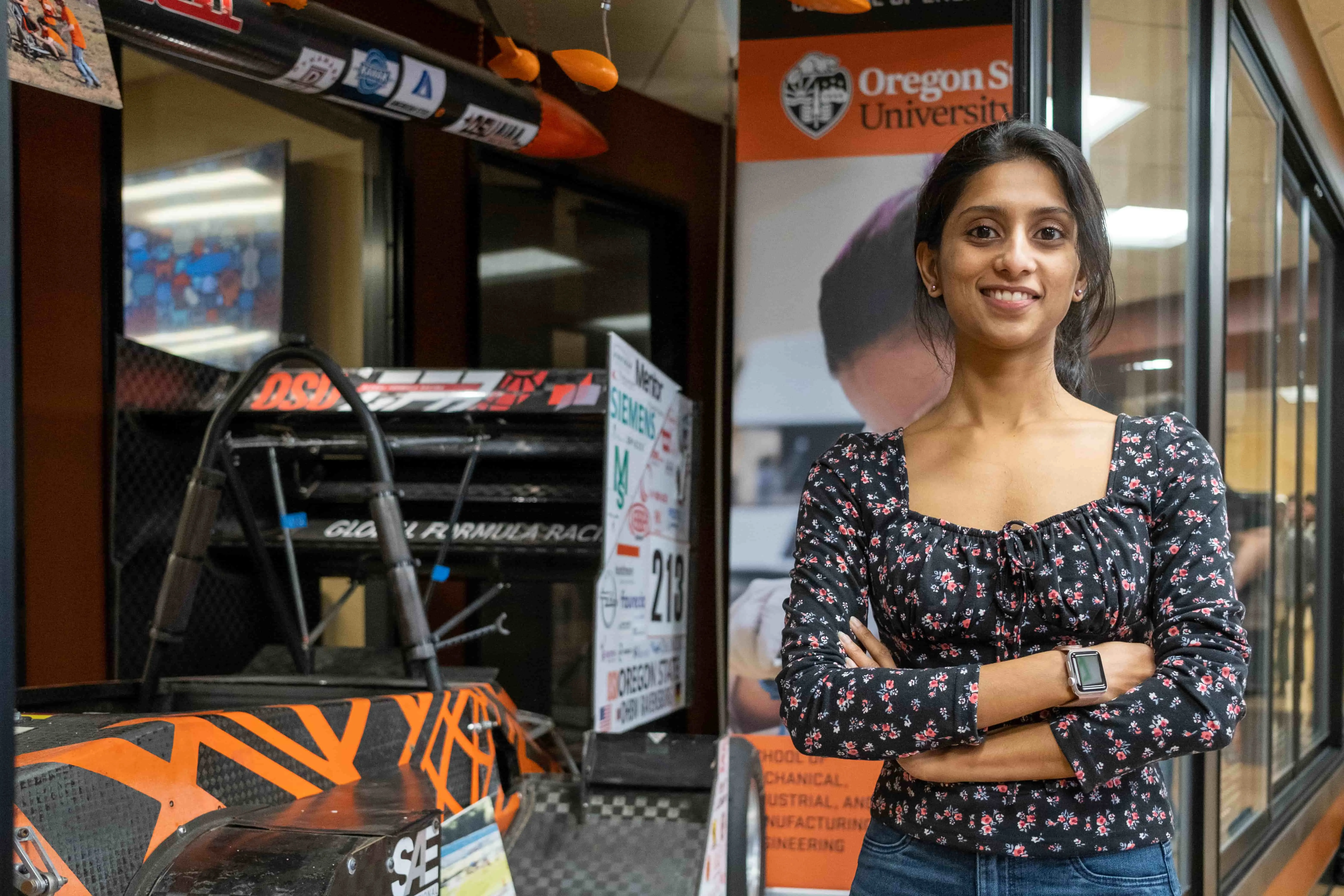 Photo of Purnima, an engineering student at OSU posing in front of some of the display items inside Rodgers Hall.