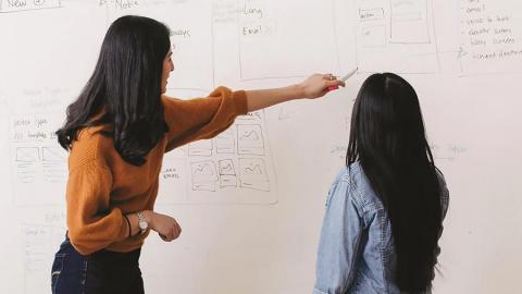 business teacher and student working at board